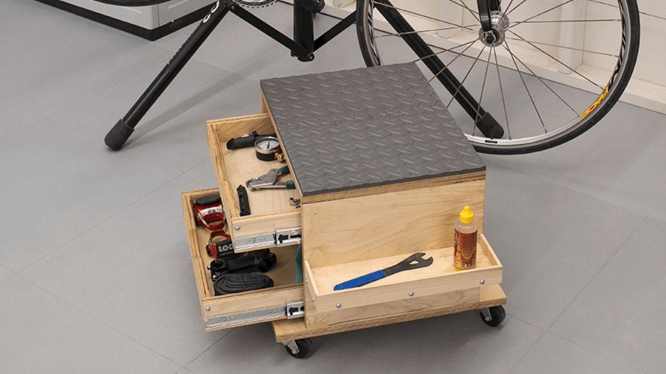 A timber rolling work seat and tool storage cart in a garage
