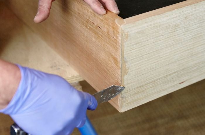 Applying putty to fill any gaps or holes in the dog bed