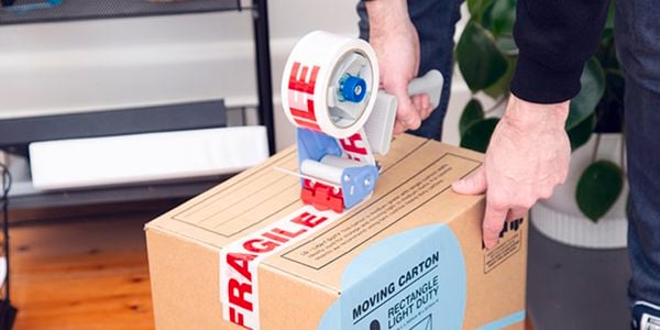 person taping up a moving boxes