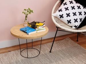 DIY wire side table with books on top, next to a chair.