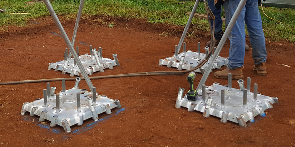 Steel base plates and poles arranged on a cleared construction site