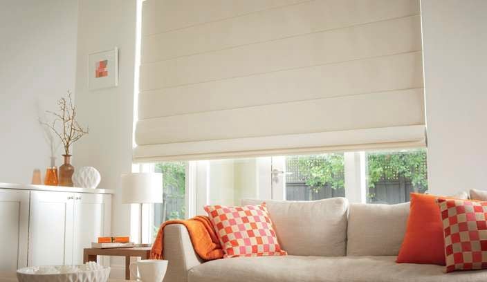 Window with cream roller blinds.