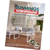 Outdoor white corner lounge sitting on a timber deck, with throw rug and plants