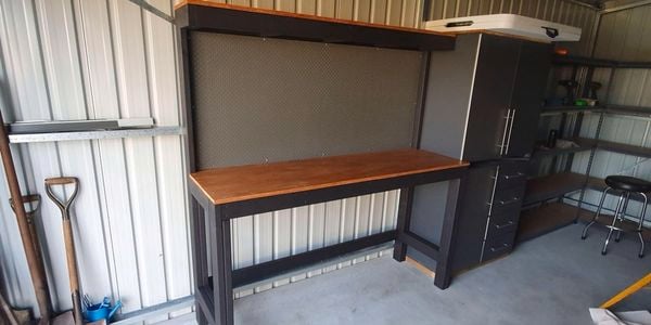 A timber workbench and steel cabinets in a garage