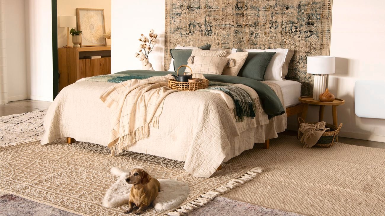Cosy bedroom featuring earth-toned furnishings and layered interior rugs.