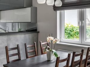 Custom Roman Blinds hanging in a dining room interior.