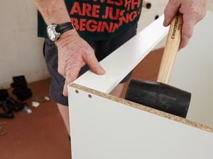 Attaching the top rail to the kitchen cabinet.
