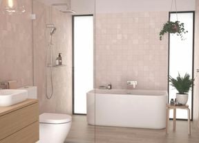 A modern Caroma bathroom in neutral tones featuring a freestanding bathtub flanked by floor-to-ceiling windows, a frameless shower screen and a timber vanity