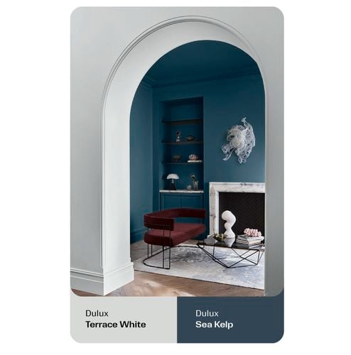 Archway leading into a room with blue walls and modern furniture.