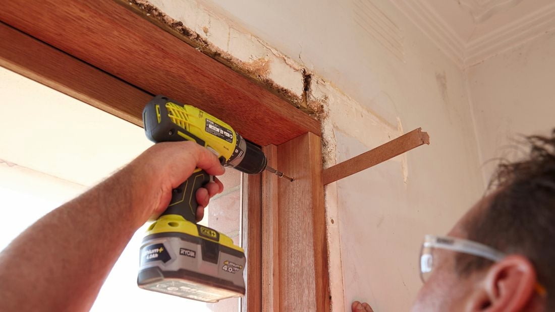 Drilling pilot holes at the top of the window frame