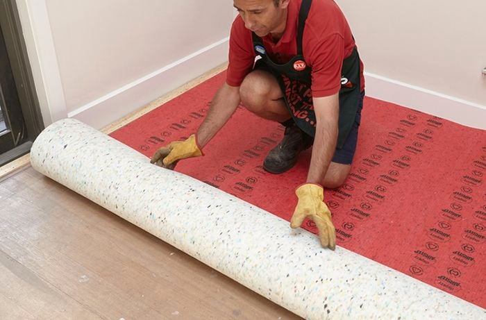 Underfelt being rolled out on subfloor by a Bunnings team member