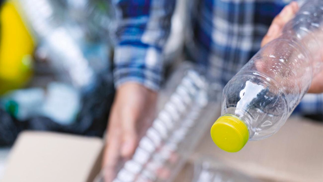 Person holding plastic bottle.