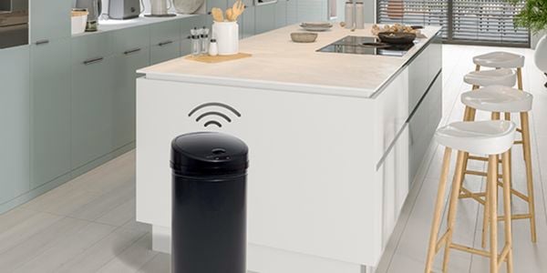 Kitchen with kitchen island, stools and black sensor bin.