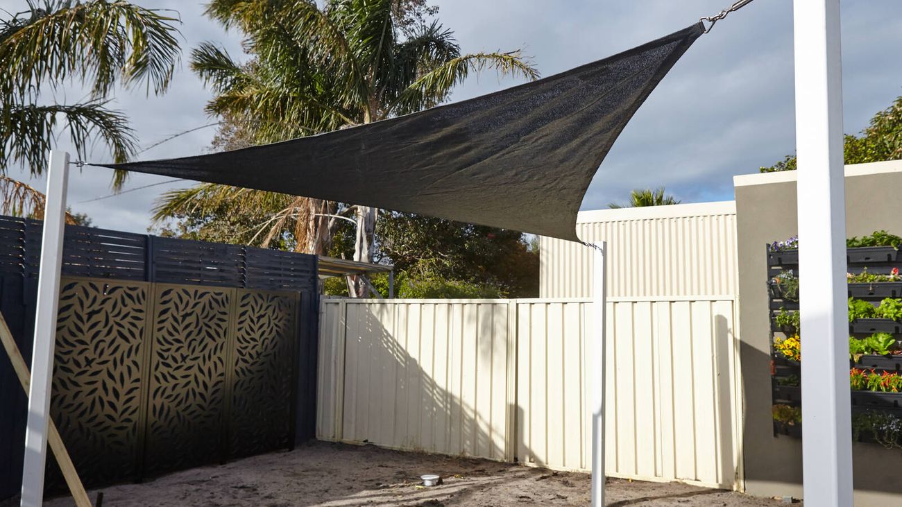 A backyard porch with a large Beech-coloured Coolaroo shade sail covering the garden.