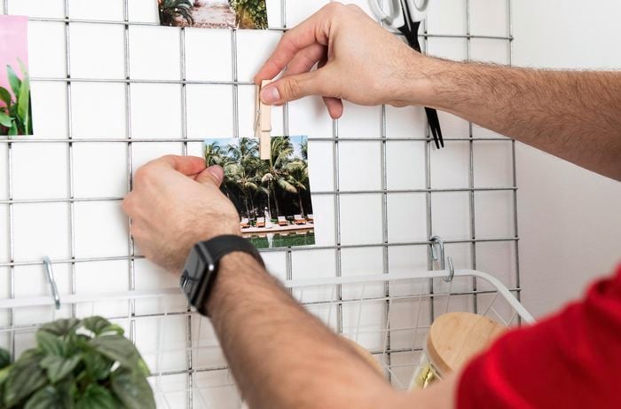 A photo being pegged to a mesh grid