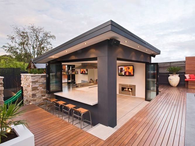 Outdoor entertaining area surrounded by decking next to a pool. 