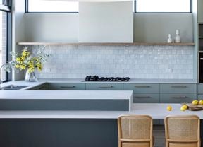 A kitchen showcasing assisted living design with comfortable seats for food prep and accessible oven and microwave