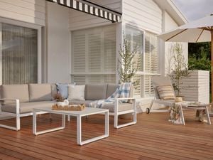 White outdoor lounge and chair, sitting on decking with potted plants