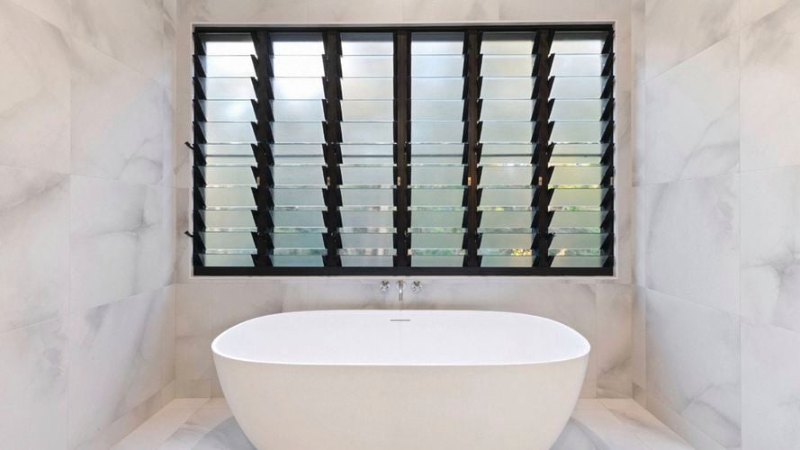 A bathroom with a bath and window in it.