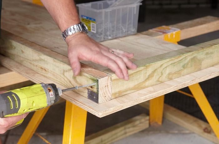 Person drilling two bits of timber frame together.