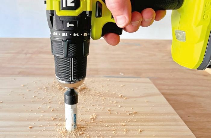 Drill in centre of wood creating hole.