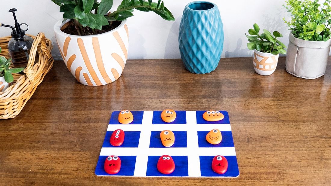 A monster themed noughts and crosses game on a wooden table