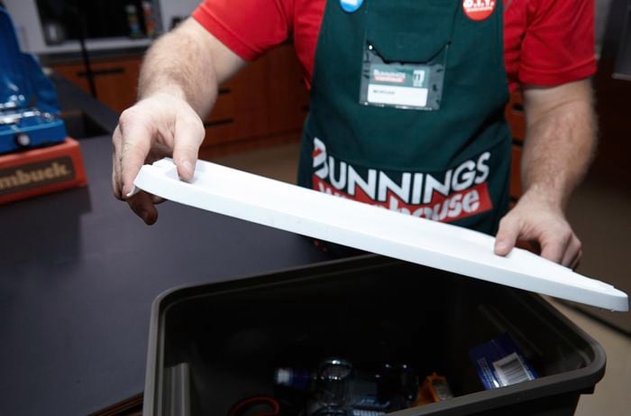 A lid being placed over a black tub with emergency equipment inside