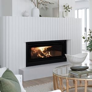 Living space with white furniture, white walls, dog sitting down on a rug and a fireplace.