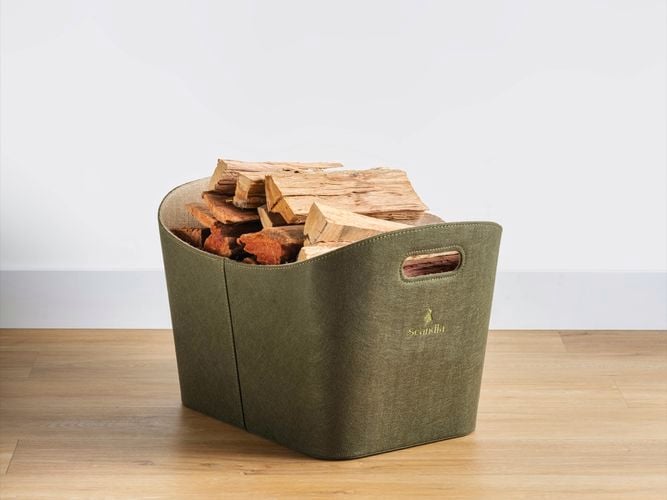 Green bag with pieces of wood in it on timber flooring.