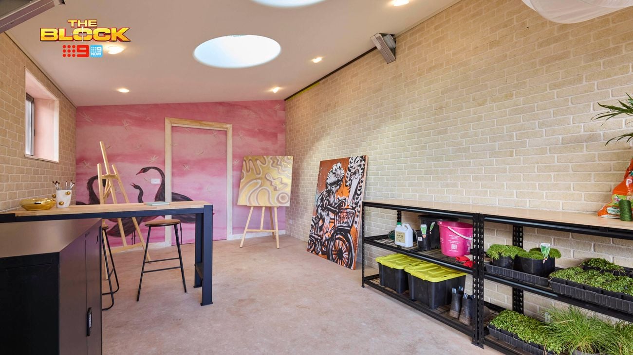 A room with paintings, storage containers and plants in it.