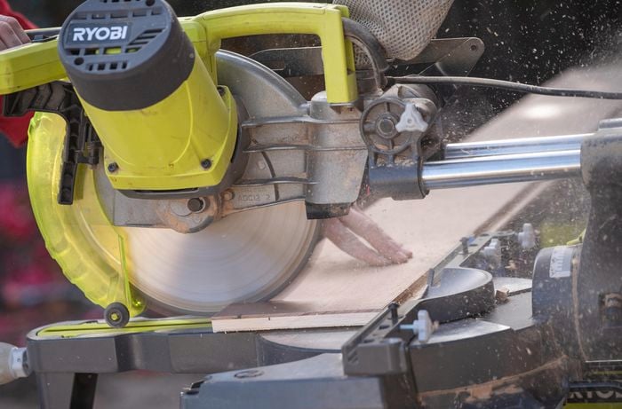 A person cutting the kickboard using a circular saw.