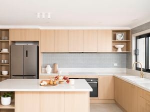  Natural Neutrals tone kitchen with brass fixtures, grey tile splashback, and a clean white island 