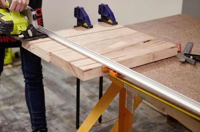 A Bunnings team member using a power saw to cut the coat rack base to size