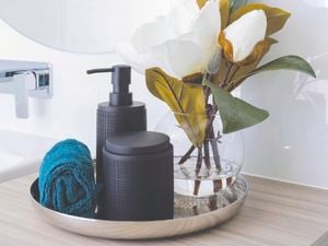 Artificial flowers on countertop with soap.