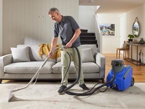 man using a britex carpet cleaner to clean cream carpet