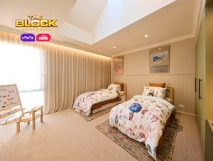 Olive and cream kids bedroom with twin beds and animal print linen, 2 coloured rugs and a wardrobe and desk on the opposite wall.