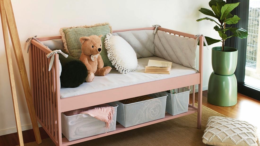 a kids couch with cushion and soft toys on it