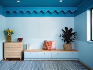 A modern room features a bold blue colour-capping design with decorative scalloped trim along the top of the wall.