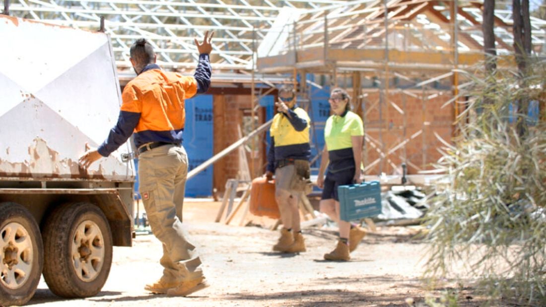 three trades people on an work site waving hello