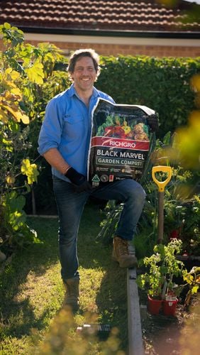 Man showing garden compost bag. 