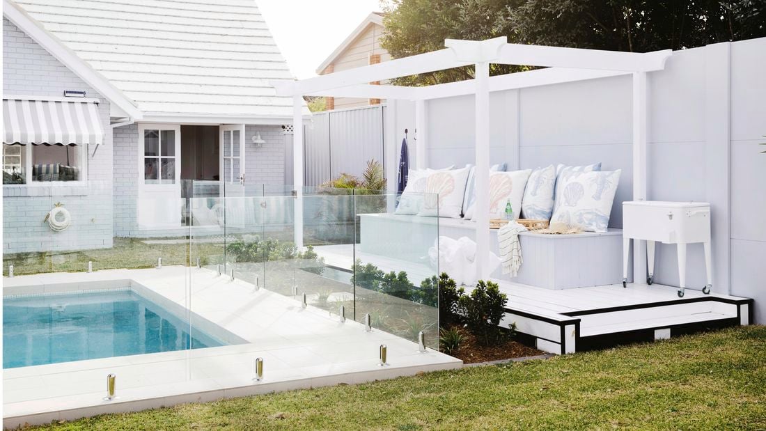 Swimming pool and outdoor room with white decking and raised platform