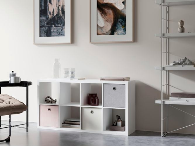 Cube shelving unit, a chair and racking next to a wall in a room