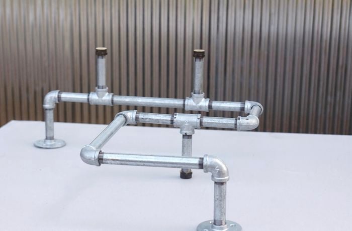 An assembled ironing board storage rack made from metal pipe