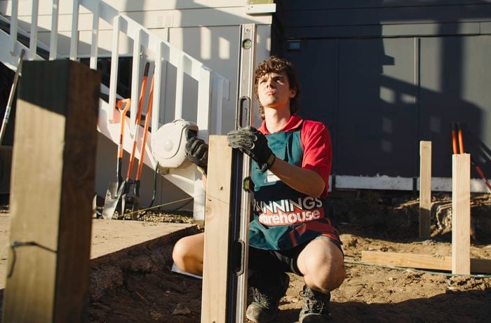 Bunnings team member installing timber post into the ground