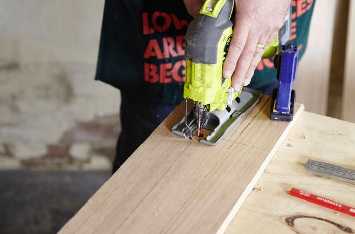 Holes being drilled into a dog bed frame for a jigsaw blade