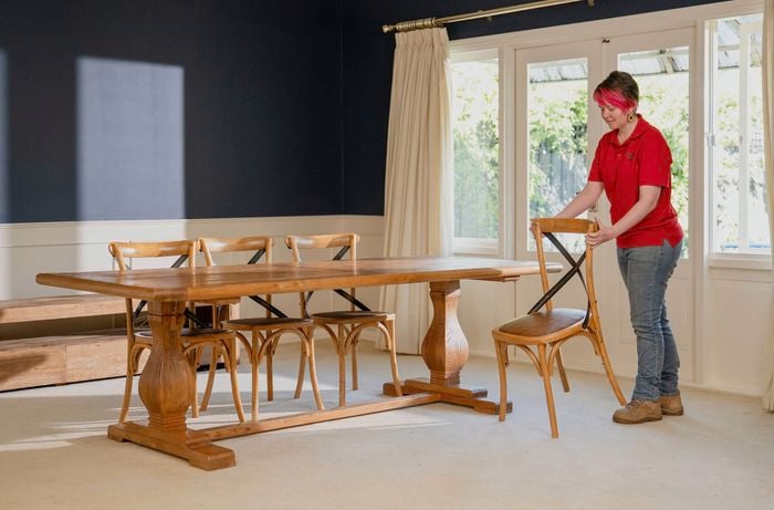 A Bunnings Team Member is preparing the area by clearing away any furniture from the floor to ensure you have full access to the carpet.