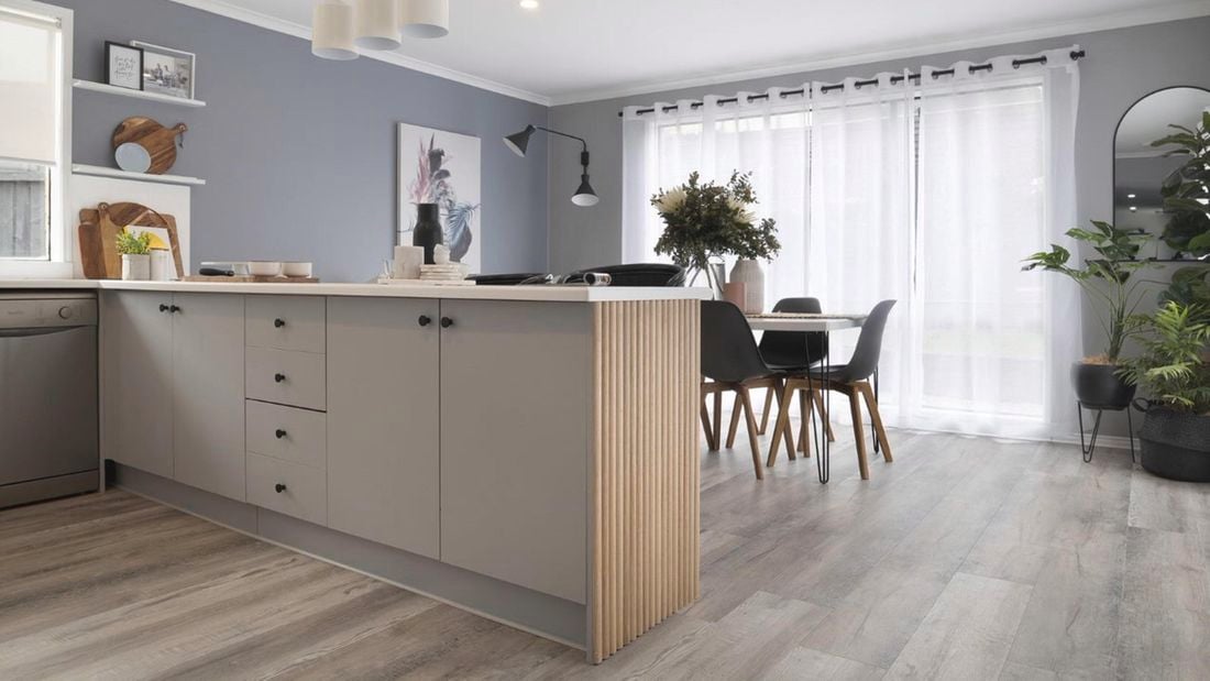 Kitchen with freshly painted cabinets, grey walls and white benchtops.