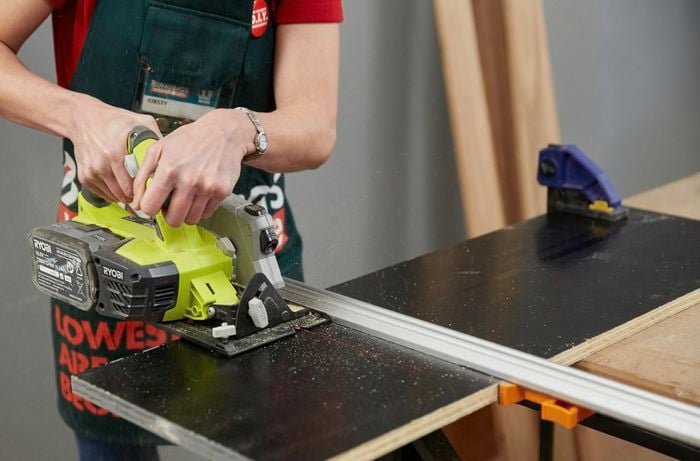 Person cutting ply with saw