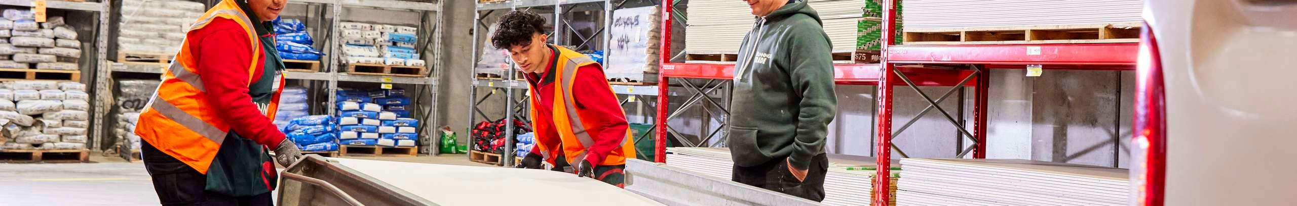 Team members loading timber into a customers trailer.