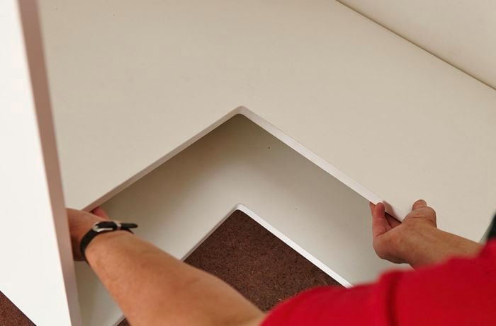 A person a fitting shelf into corner cabinet